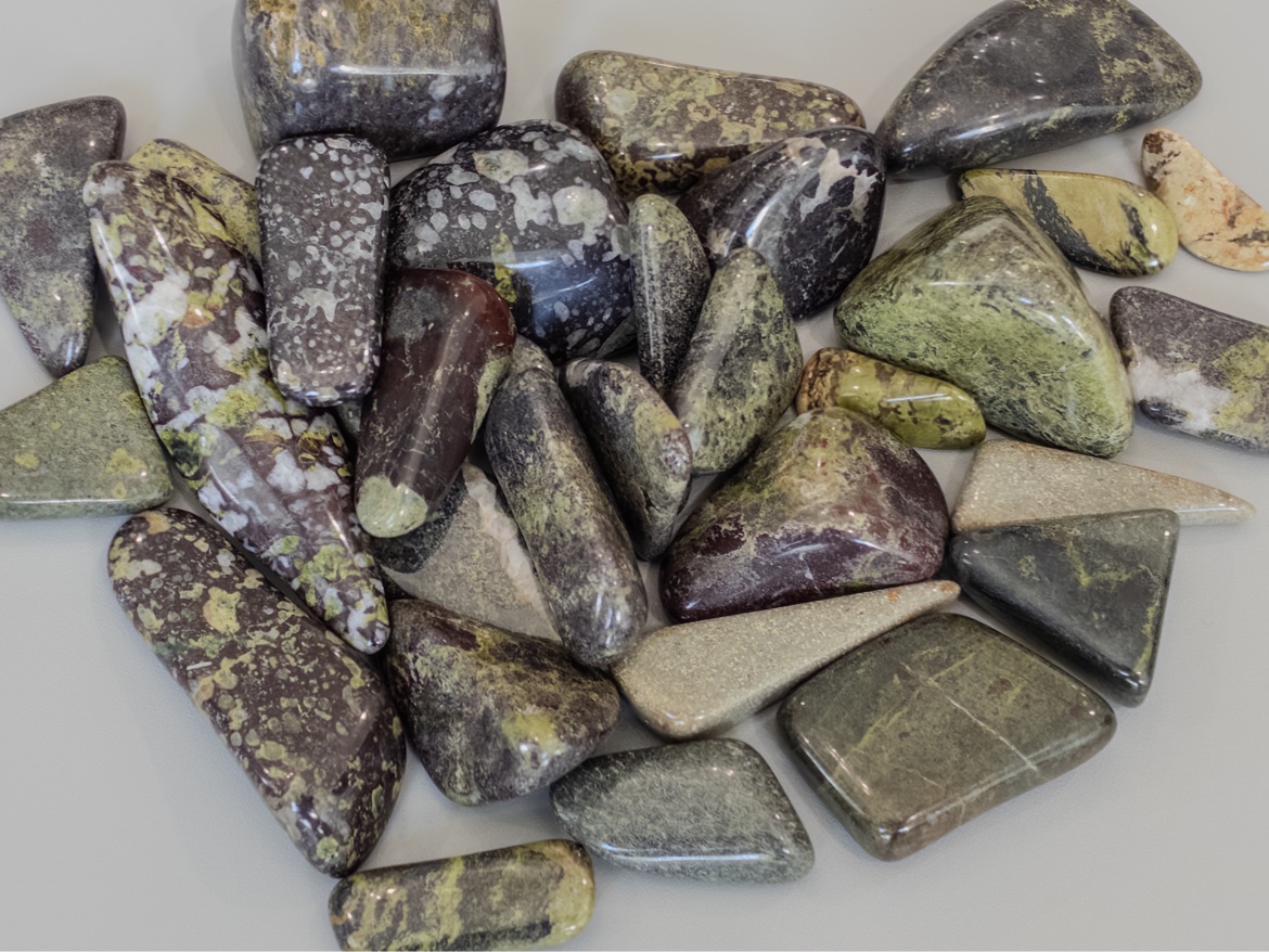 Fresh from the tumbler: dark polished stones with olive-green and burgundy mottling